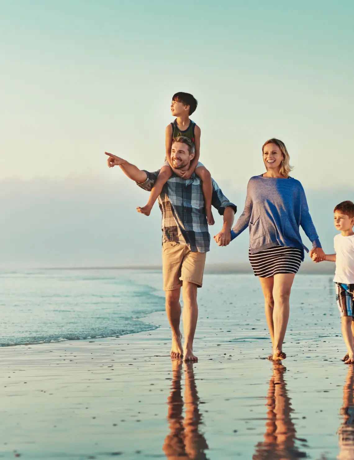 Gezin wandelt samen langs het strand